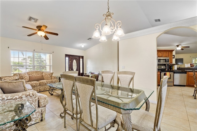 dining room with ceiling fan with notable chandelier, light tile floors, and lofted ceiling