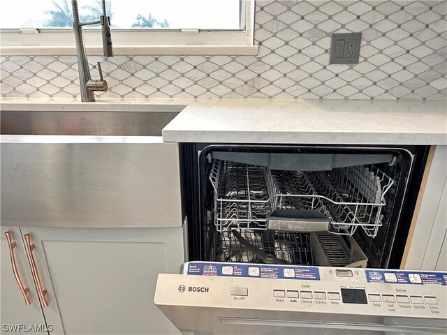 details featuring backsplash and dishwasher