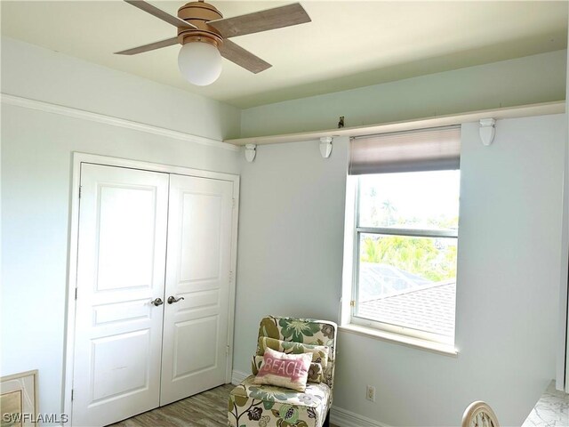 living area with light hardwood / wood-style flooring and ceiling fan