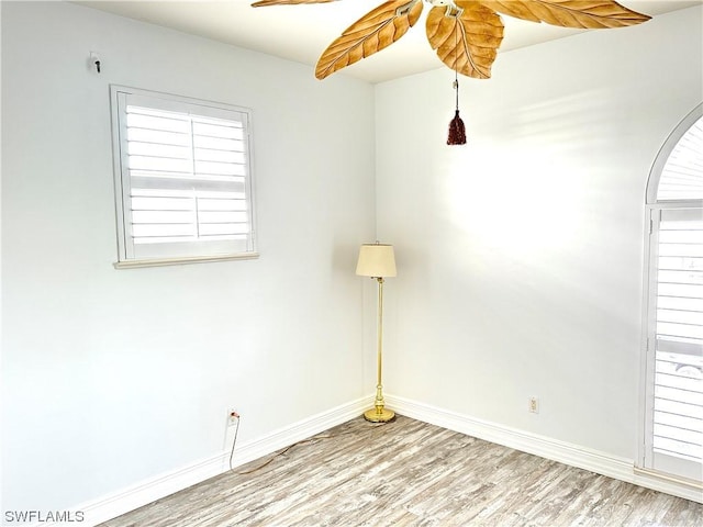 empty room with baseboards and wood finished floors