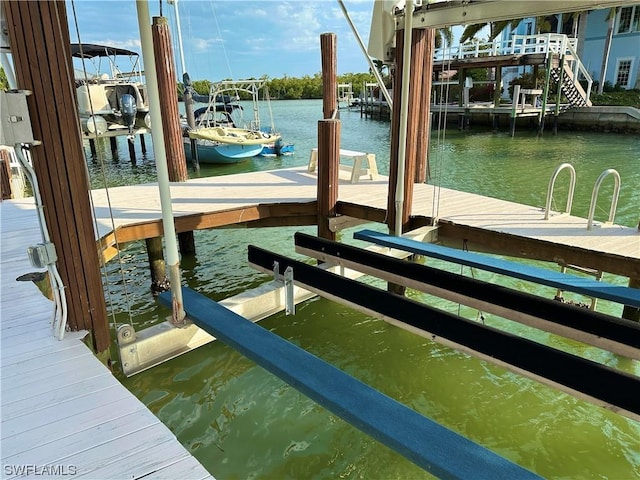 dock area with a water view and boat lift