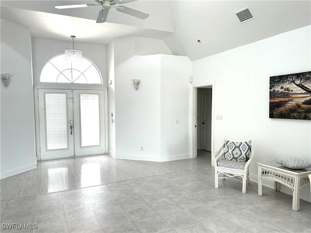 entryway with ceiling fan with notable chandelier, high vaulted ceiling, french doors, and visible vents