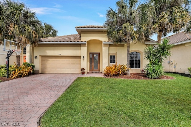 mediterranean / spanish home with a front lawn and a garage