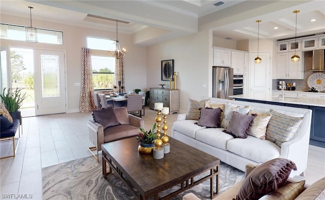 tiled living room featuring an inviting chandelier, sink, a towering ceiling, and ornamental molding