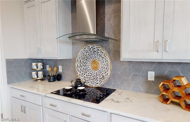 kitchen with white cabinetry, black electric stovetop, backsplash, and wall chimney range hood