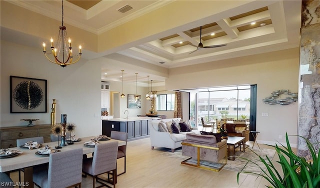 interior space with coffered ceiling, ceiling fan with notable chandelier, light hardwood / wood-style floors, a towering ceiling, and ornamental molding