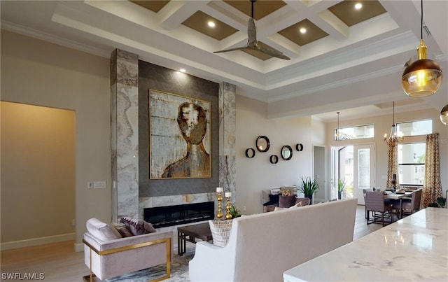 living room featuring coffered ceiling, a fireplace, beam ceiling, ceiling fan with notable chandelier, and light wood-type flooring