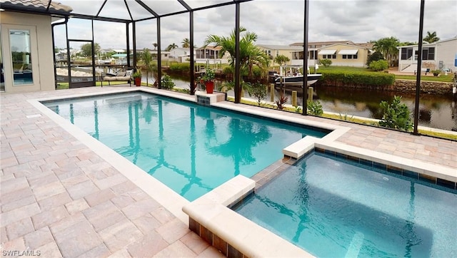 view of swimming pool featuring a patio area, an in ground hot tub, and a lanai