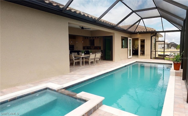 view of swimming pool with an in ground hot tub, glass enclosure, ceiling fan, and a patio