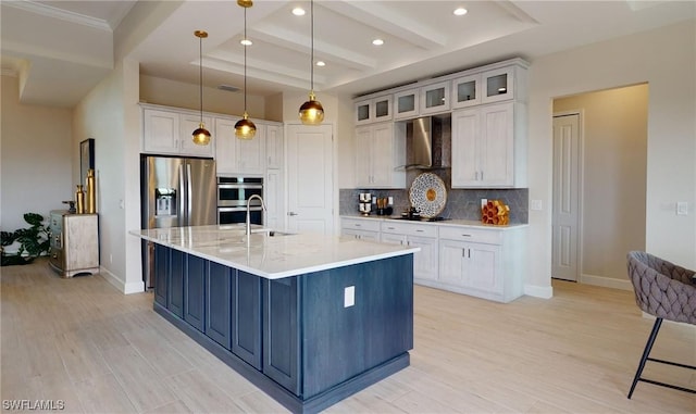 kitchen featuring decorative light fixtures, light hardwood / wood-style floors, white cabinets, tasteful backsplash, and wall chimney exhaust hood