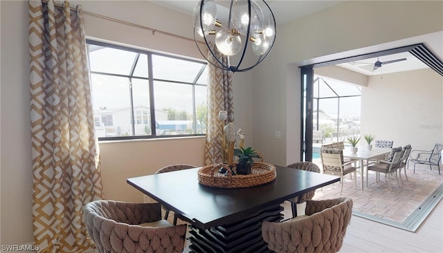 dining space with ceiling fan with notable chandelier and light wood-type flooring