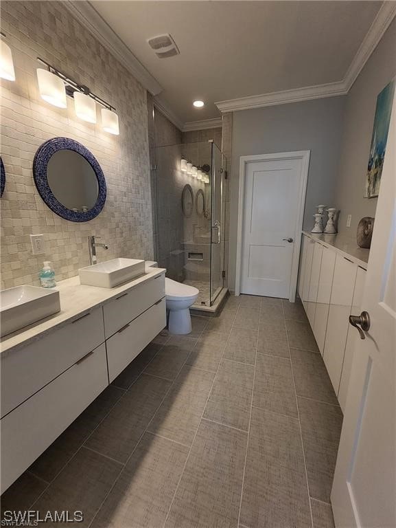 bathroom with vanity, crown molding, tile patterned flooring, toilet, and an enclosed shower