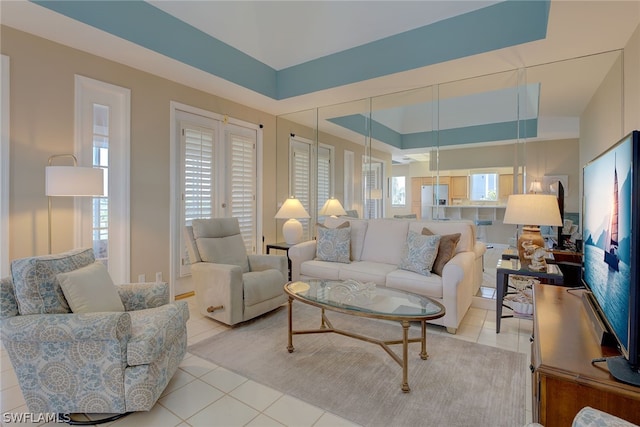 tiled living room with a raised ceiling and a healthy amount of sunlight