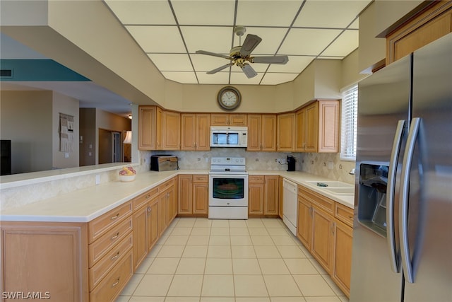 kitchen with white appliances, sink, decorative backsplash, ceiling fan, and kitchen peninsula