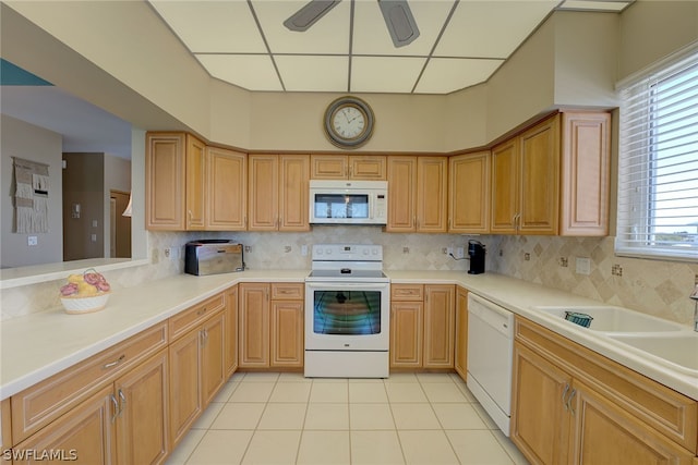 kitchen featuring backsplash, sink, light tile patterned flooring, and white appliances