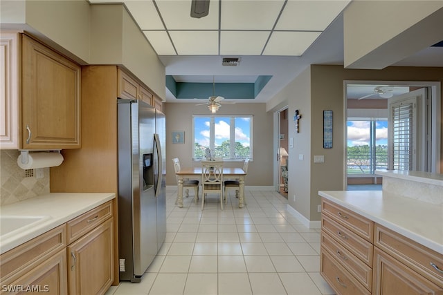 kitchen with backsplash, sink, stainless steel refrigerator with ice dispenser, ceiling fan, and light tile patterned floors