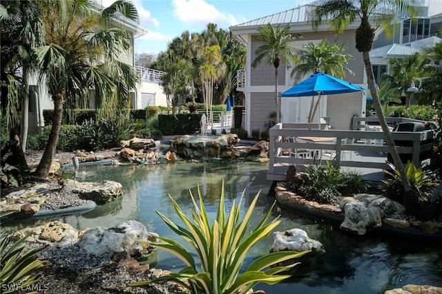 view of pool featuring a small pond