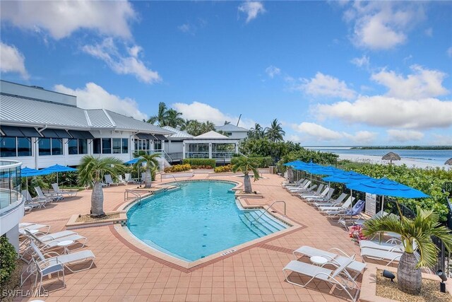 view of swimming pool with a patio and a water view