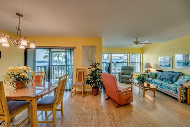 dining room with light hardwood / wood-style floors and ceiling fan with notable chandelier