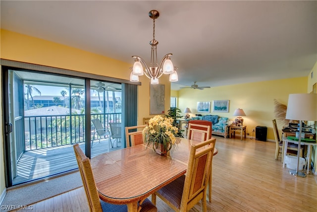 dining area with light hardwood / wood-style floors and ceiling fan with notable chandelier