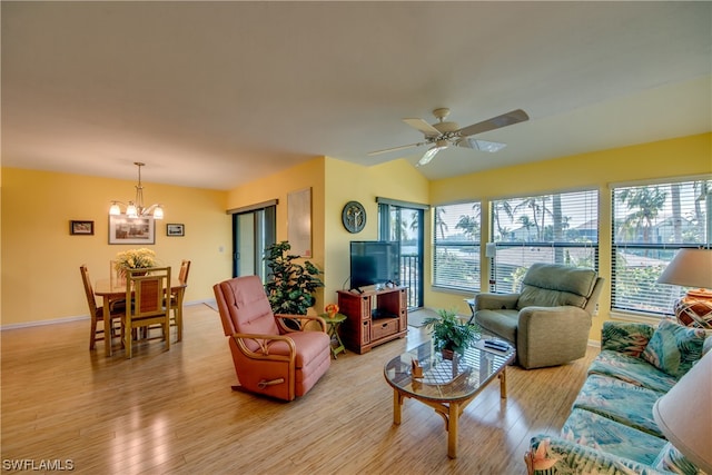 living room with light hardwood / wood-style floors and ceiling fan with notable chandelier