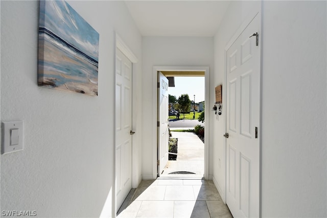 doorway to outside featuring light tile flooring