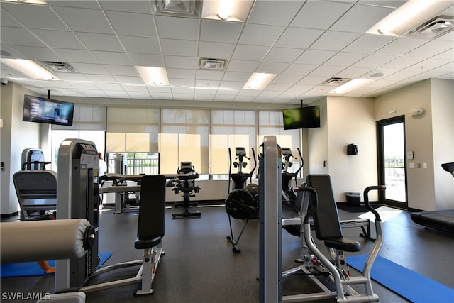 gym with a paneled ceiling and plenty of natural light