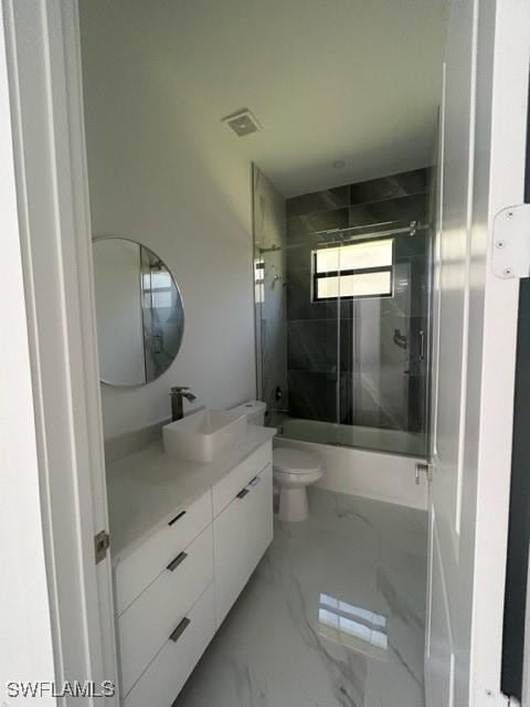 full bathroom with vanity, toilet, and bath / shower combo with glass door