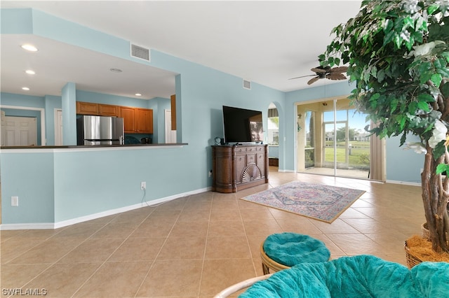 unfurnished living room featuring ceiling fan and light tile patterned floors