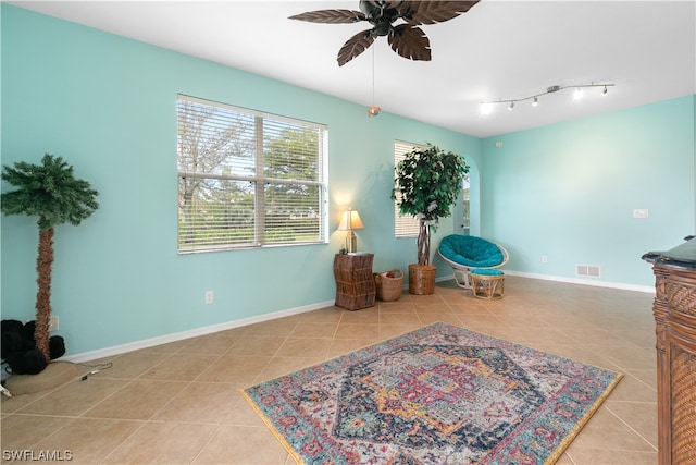 sitting room featuring light tile patterned flooring and ceiling fan