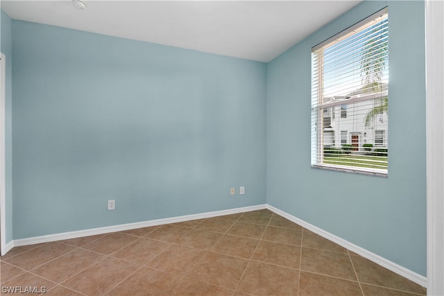 spare room with tile patterned floors and a healthy amount of sunlight