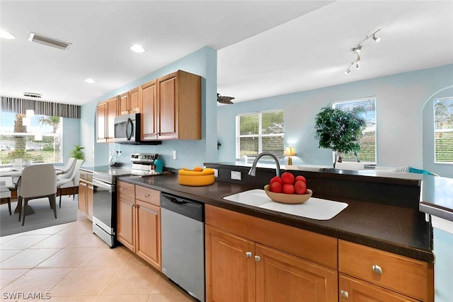 kitchen featuring appliances with stainless steel finishes, light tile patterned flooring, and sink