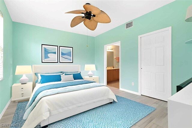 bedroom featuring ceiling fan, light wood-type flooring, and ensuite bathroom