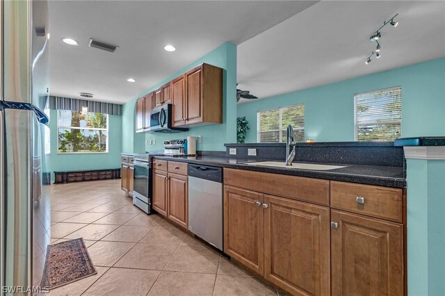 kitchen featuring light tile patterned flooring, stainless steel appliances, hanging light fixtures, and sink