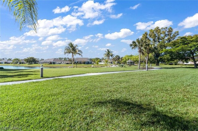 view of community featuring a lawn and a water view