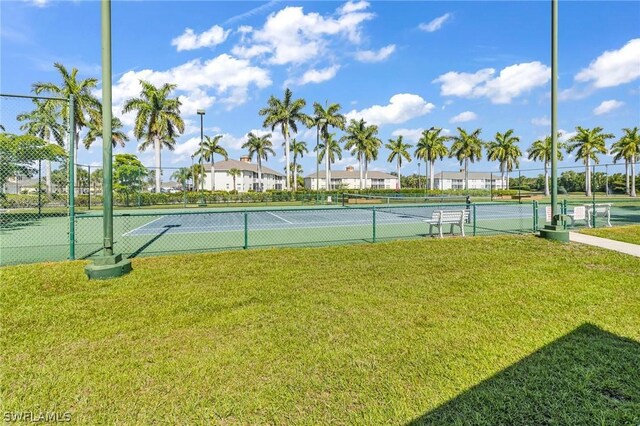 view of sport court with a lawn