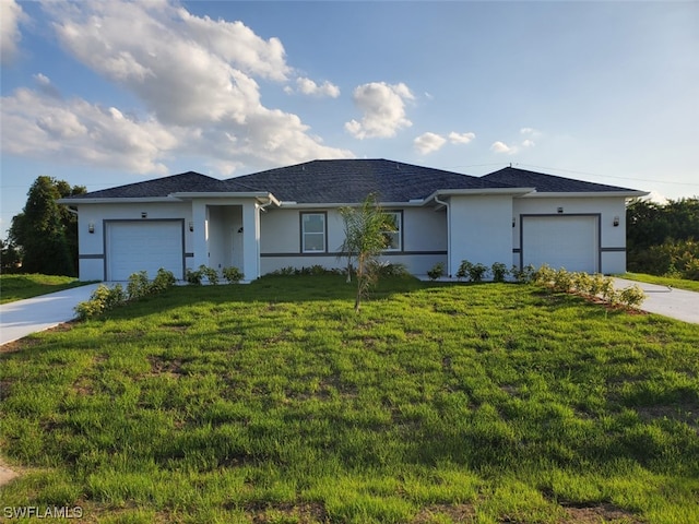 ranch-style home with a garage and a front lawn