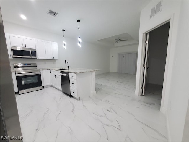 kitchen featuring ceiling fan, hanging light fixtures, kitchen peninsula, white cabinets, and appliances with stainless steel finishes