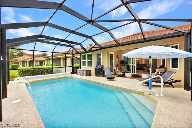 view of swimming pool featuring a grill, glass enclosure, and a patio area