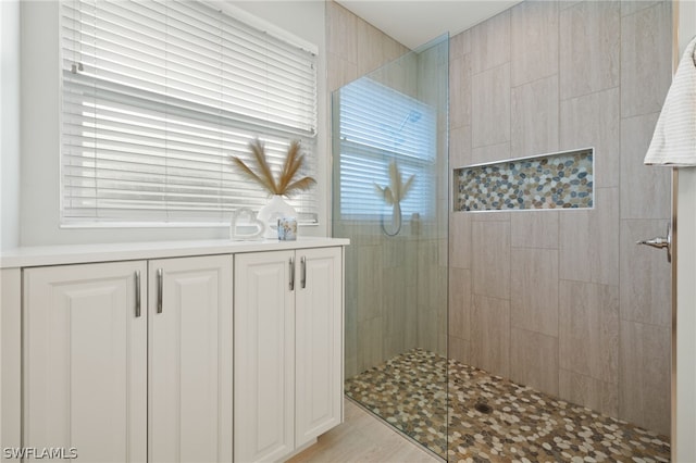 bathroom with hardwood / wood-style flooring and tiled shower