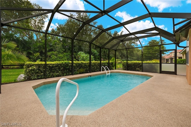 view of pool with a patio area and glass enclosure