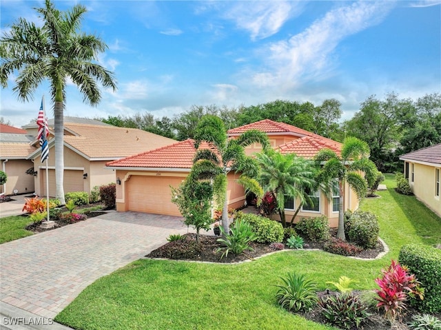 mediterranean / spanish-style house featuring a garage and a front lawn