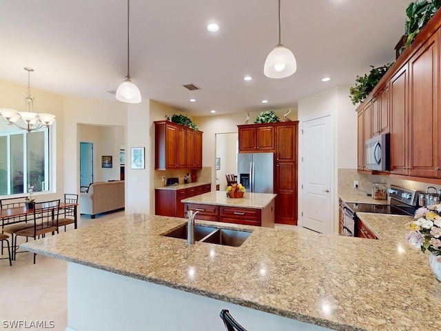 kitchen featuring an inviting chandelier, appliances with stainless steel finishes, decorative light fixtures, and sink