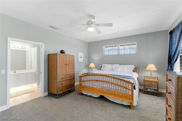 bedroom featuring carpet floors, visible vents, ensuite bathroom, a ceiling fan, and baseboards