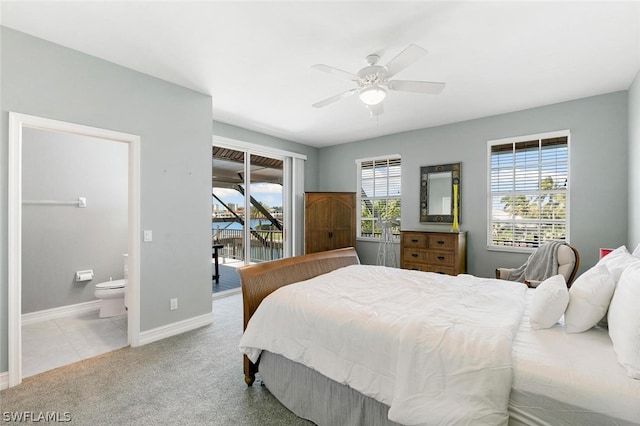 carpeted bedroom with access to exterior, ceiling fan, ensuite bath, and multiple windows