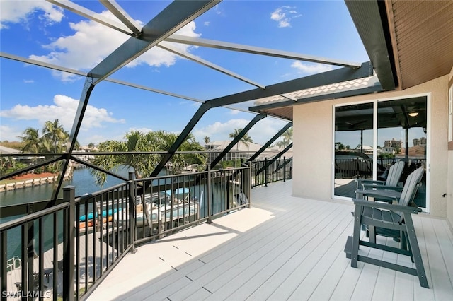 wooden deck with glass enclosure and a water view