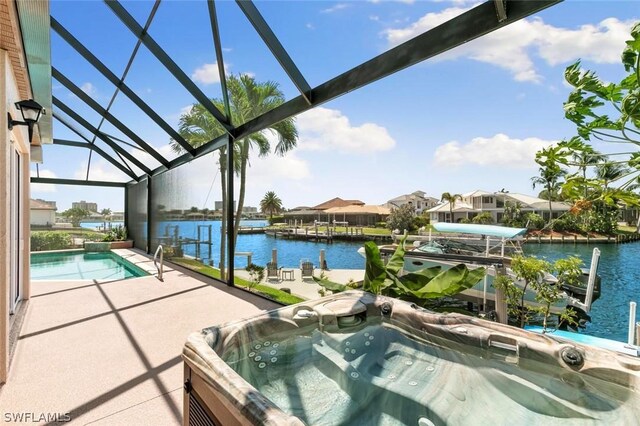 outdoor pool with a hot tub, a boat dock, glass enclosure, a water view, and a patio area