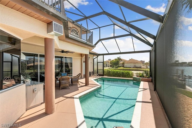 view of swimming pool featuring glass enclosure, ceiling fan, and a patio area