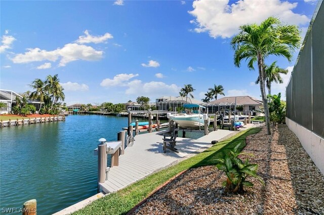 dock area with a lanai, a water view, and boat lift