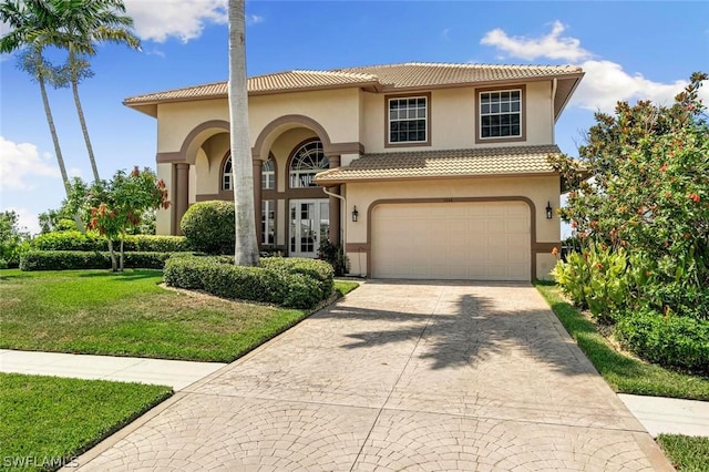 mediterranean / spanish-style home featuring french doors, a garage, and a front lawn